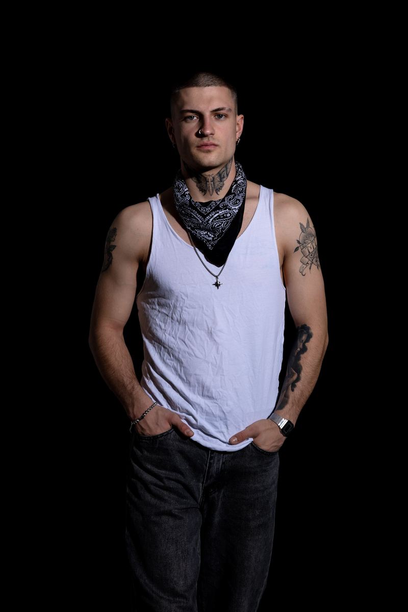 Tätowierter Mann im weissen Tanktop mit Bandana